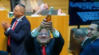 איתמר בן גביר במליאת הכנסת לאחר ההכרזה על אישור חוק עונש מוות למחבלים עם שמפניה בידו