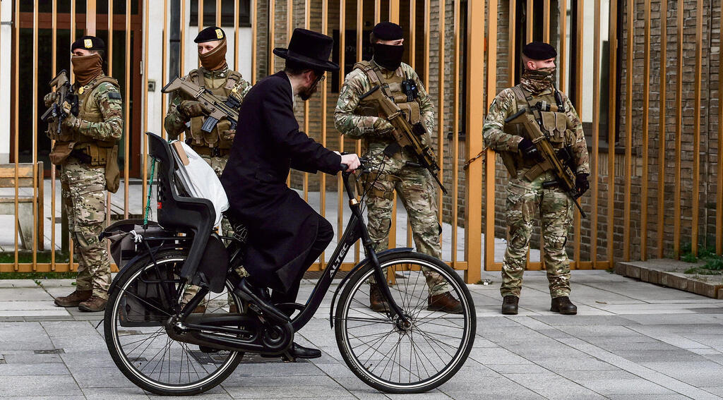 חרדי בלגי לצד כוחות צבא באנטוורפן. "הפושעים משתמשים בחומרים שמתאימים יותר להפחדות"