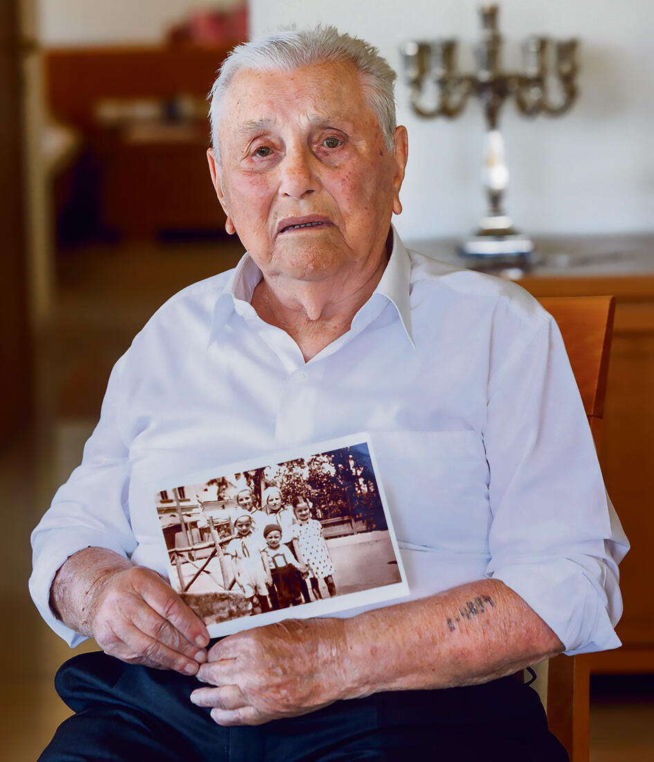 יוסקה אוחז בתמונה שלו (משמאל למעלה) ושל אחיו בילדותם