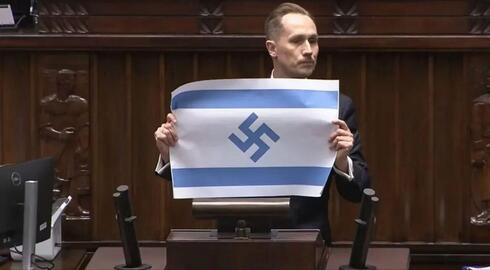 Polish MP displays Israeli flag with swastika during Holocaust Day parliament speech in Warsaw