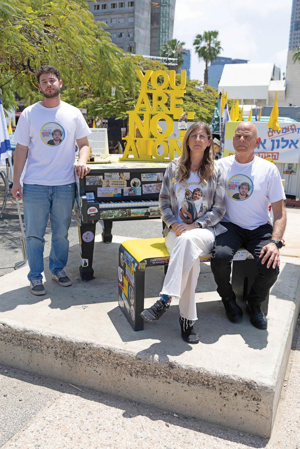 עידית, קובי ורונן אהל לצד הפסנתר שהוצב לכבוד אלון בכיכר החטופים, אפריל 2 (צילום: טל שחר) עידית, קובי ורונן אהל לצד הפסנתר שהוצב לכבוד אלון בכיכר החטופים, אפריל 2