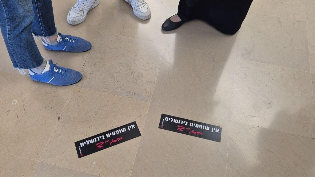 סטיקרים שהודבקו על הרצפה בבית המשפט (צילום: אלכס קולומויסקי) פעילי ימין הדביקו סטיקרים על הרצפה