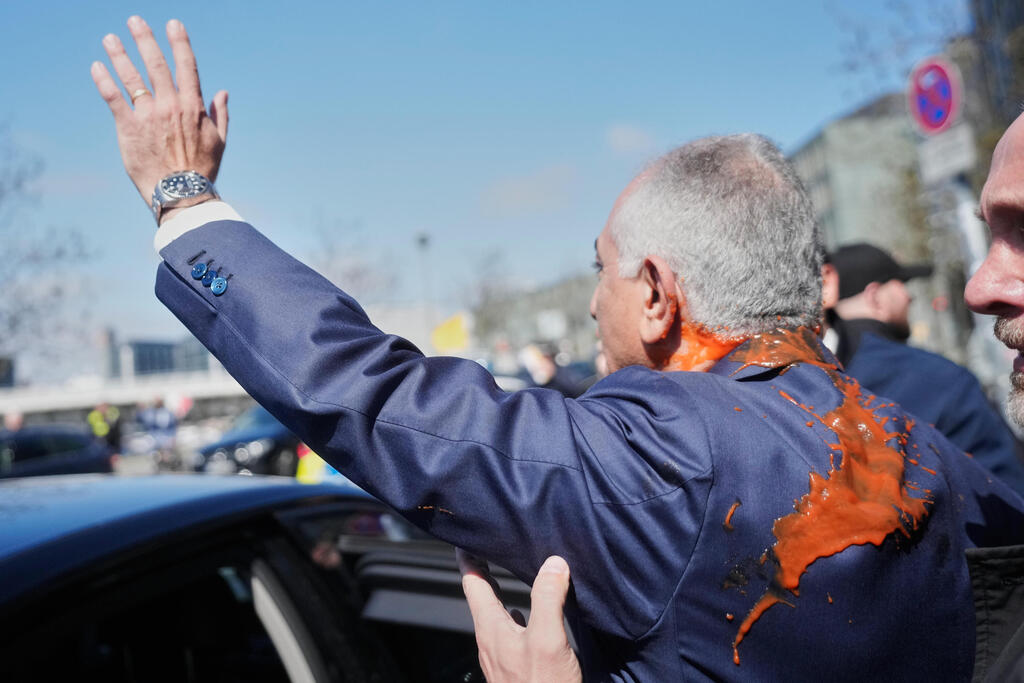 צבע אדום, על רזא פהלווי (צילום: AP Photo/Markus Schreiber) מפגין איראני מתיז צבע על רזא פהלווי במהלך ביקורו בברלין