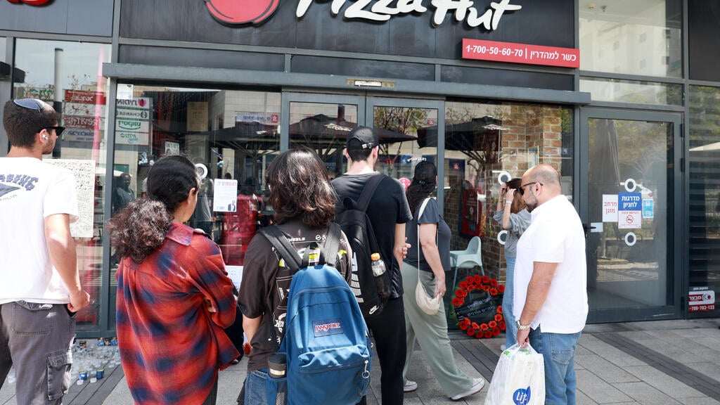 עשרות התאספו מול הפיצרייה והדליקו נרות נשמה (צילום: דנה קופל) אנדרטה מחוץ לפיצרייה לימנו בנימין זלקה ז"ל