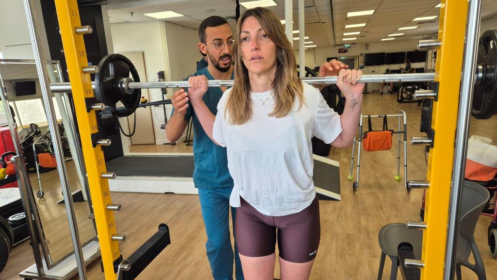 במהלך השיקום האינטנסיבי. בתמונה: עם הפיזיותרפיסט יצחק שוקר (צילום: דוברות בית החולים השיקומי רעות) ענבל מיכאלי ניצלה מ תאונת אופנוע ועברה שיקום בבית החולים השיקומי רעות