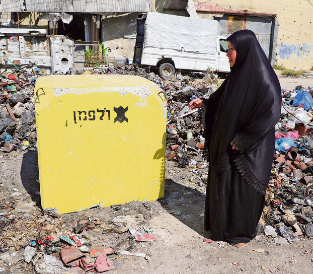 עזתית עוברת ליד לבנה שהיא חלק מסימון הקו הצהוב ברצועה