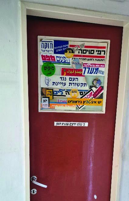 דלת השירותים שעליה נתלו סטיקרים של מפלגות מכל קצוות הקשת