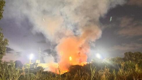 Train passes beside flames as fire rages along Yarkon River in Ramat Gan | Watch