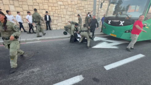 Dozens of ultra-Orthodox protesters, mostly children, block buses at Jerusalem entrance