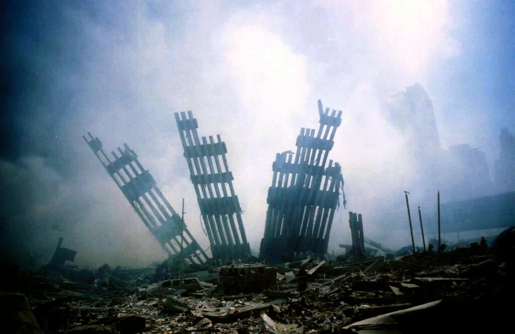The ruins of the World Trade Center stand amid smoke and debris following the Sept. 11, 2001, terrorist attacks in New York (Photo: AP Photo/Alexandre Fuchs, File) אסון התאומים הפיגוע במגדלי התאומים 11 בספטמבר 2001