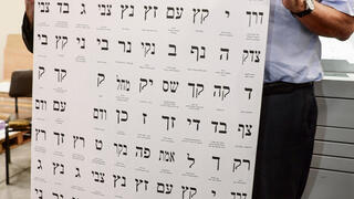 סולברג (מימין) עם פתקי המפלגות. מביט הישראלי, ואין לו פתרון